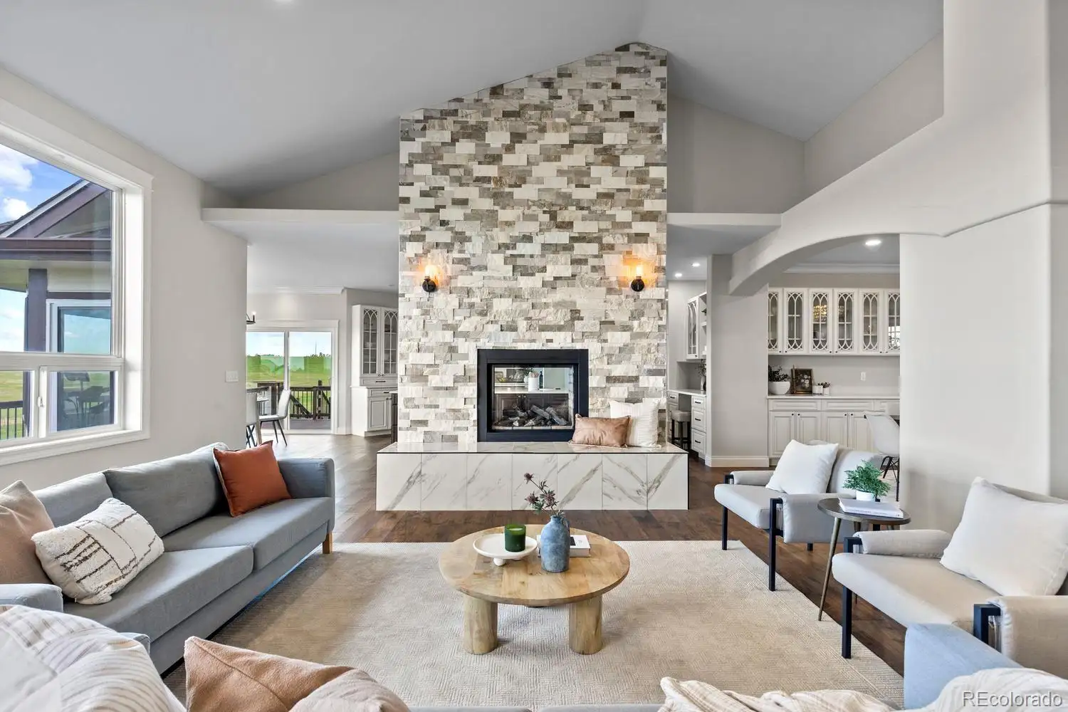 Great room with a two-story stacked-stone fireplace