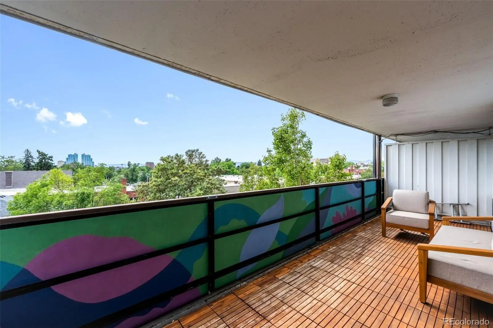 Covered balcony with treetop and city views