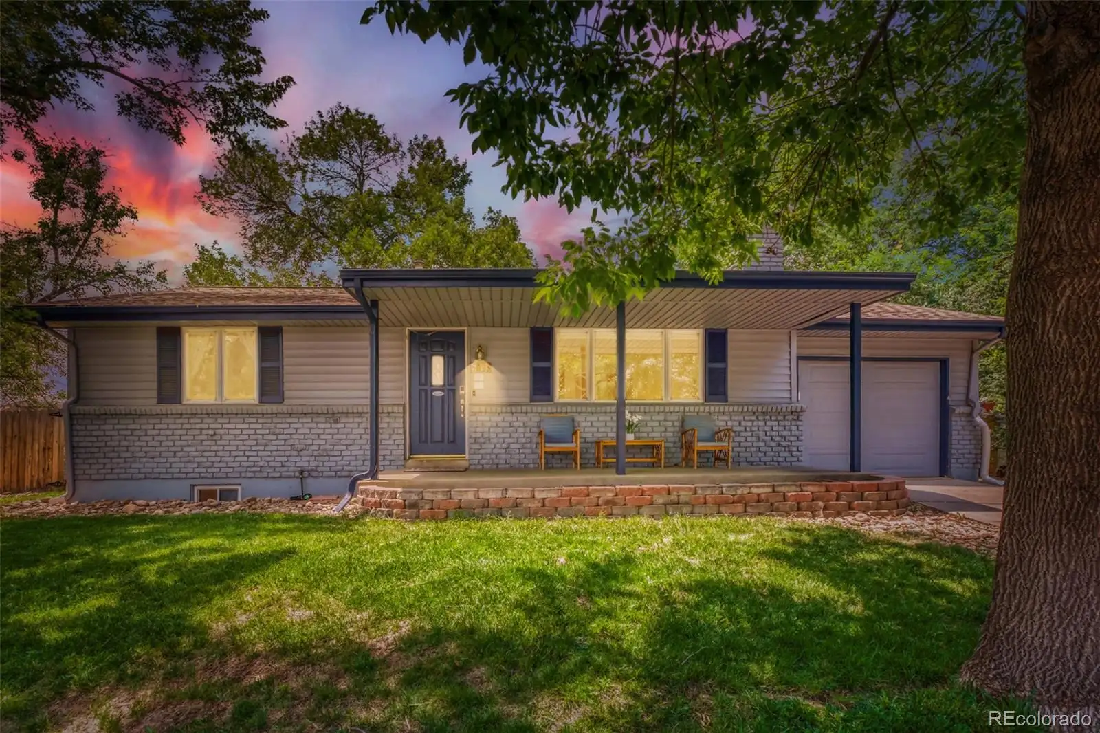 Front exterior at dusk: a single-story ranch beneath a mature shade tree