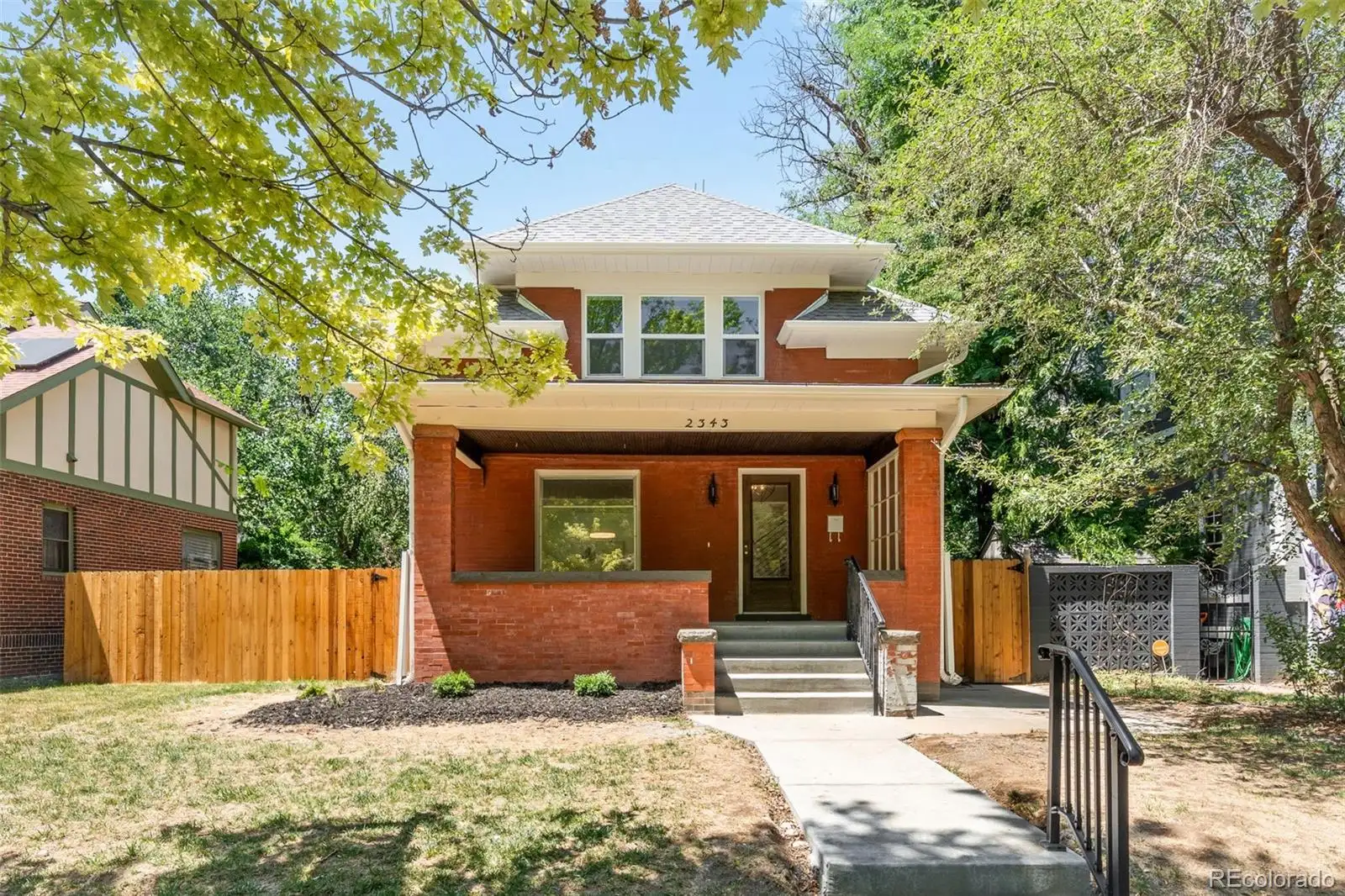 Street view of the brick bungalow and side yard