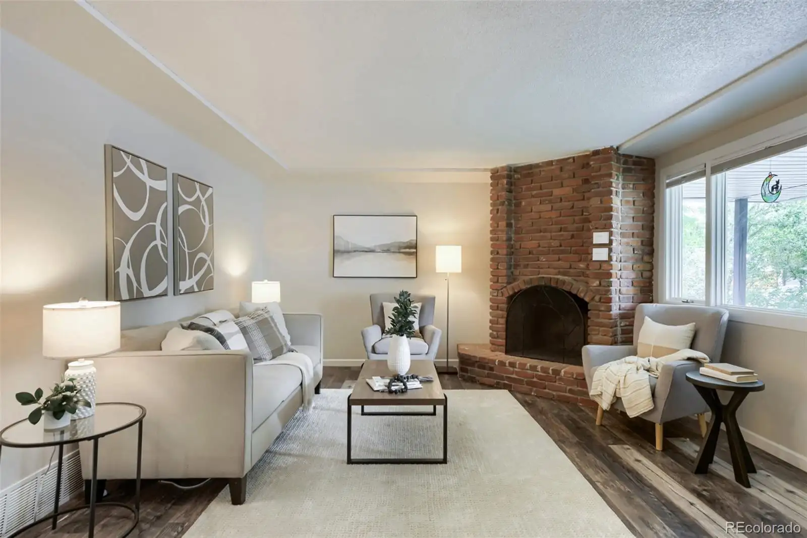 Living room with a brick corner fireplace and picture window