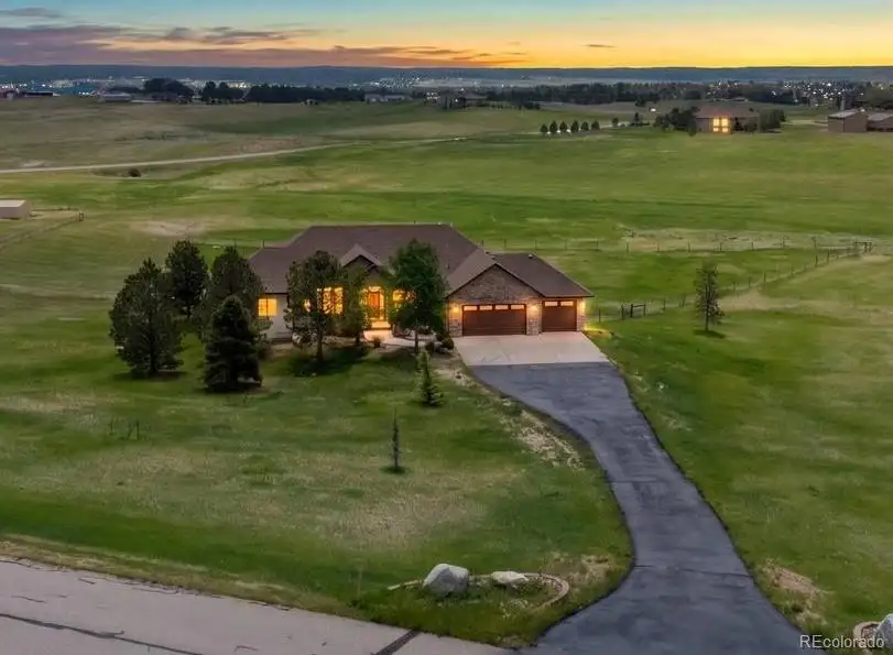 Aerial view at dusk of the home on its acreage
