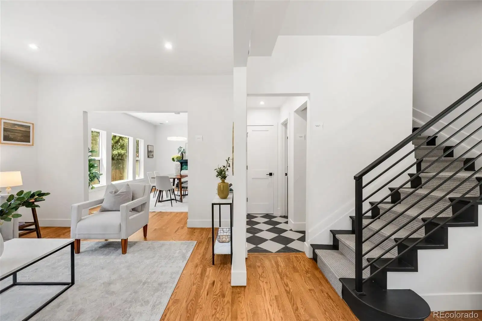 Entry and living area with a black steel stair railing