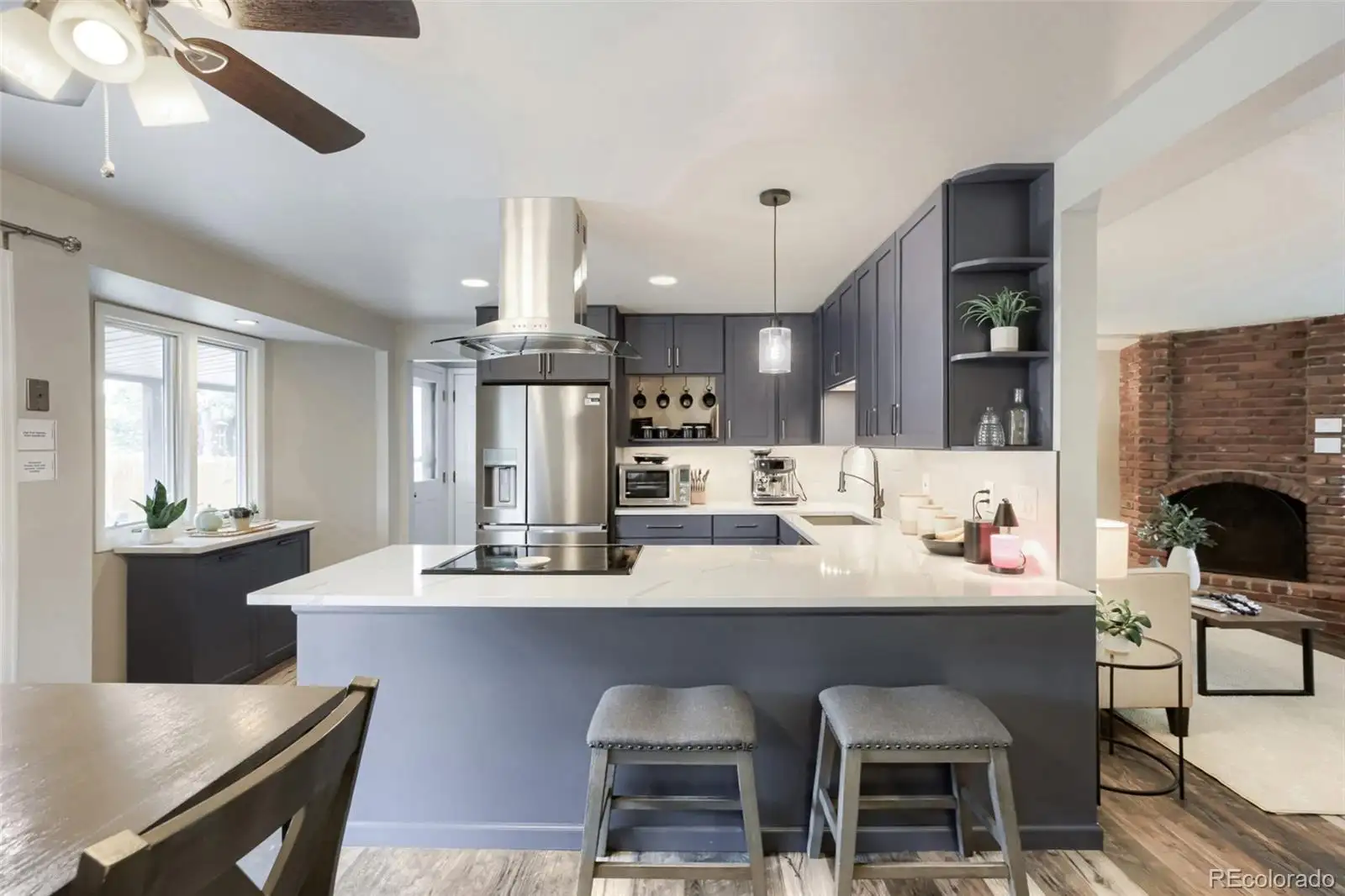 Kitchen peninsula with slate-blue cabinetry, looking toward the living room fireplace