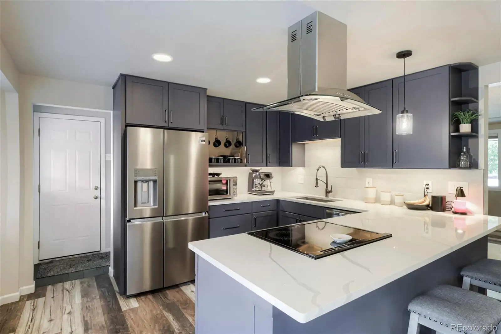 Kitchen with stainless appliances and a range hood
