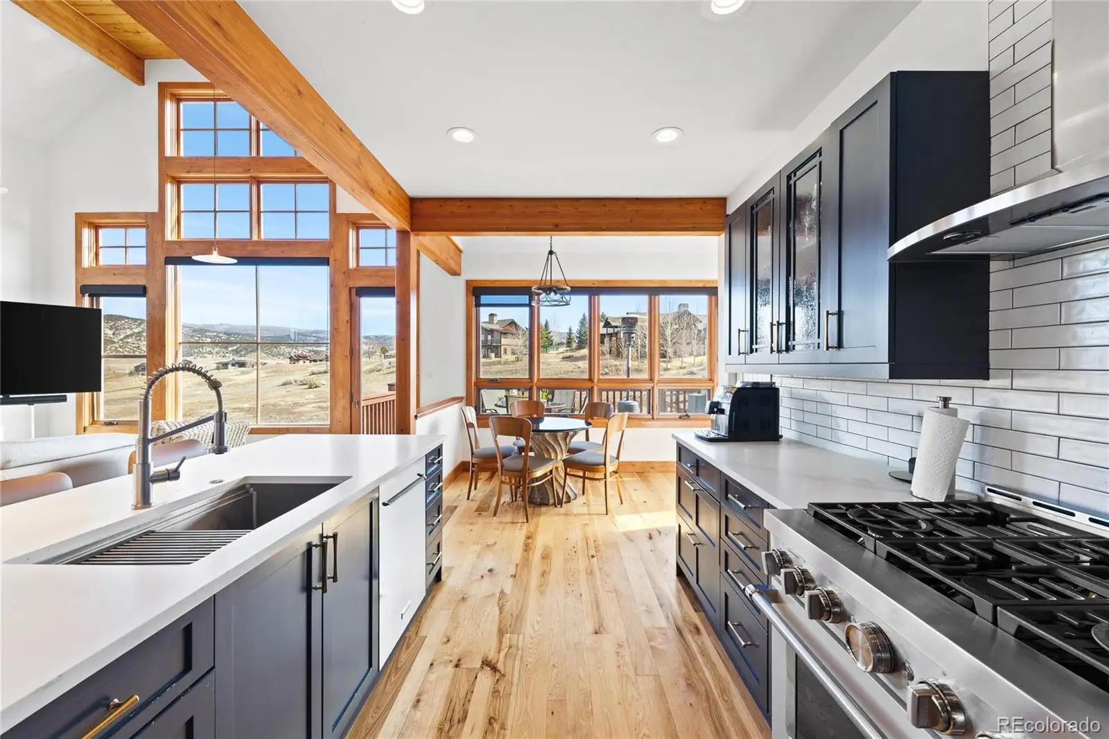 Kitchen with navy cabinetry, white counters and a gas range