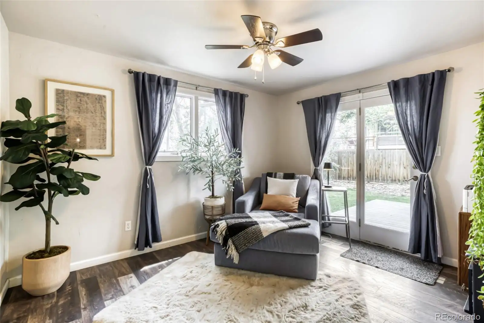Main-level bedroom staged as a sitting room, with a sliding door to the patio