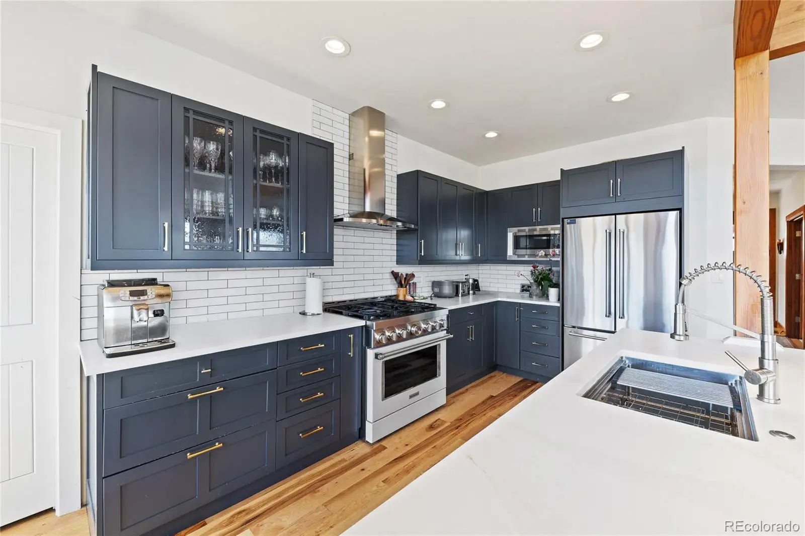 Kitchen with glass-front upper cabinets and stainless appliances