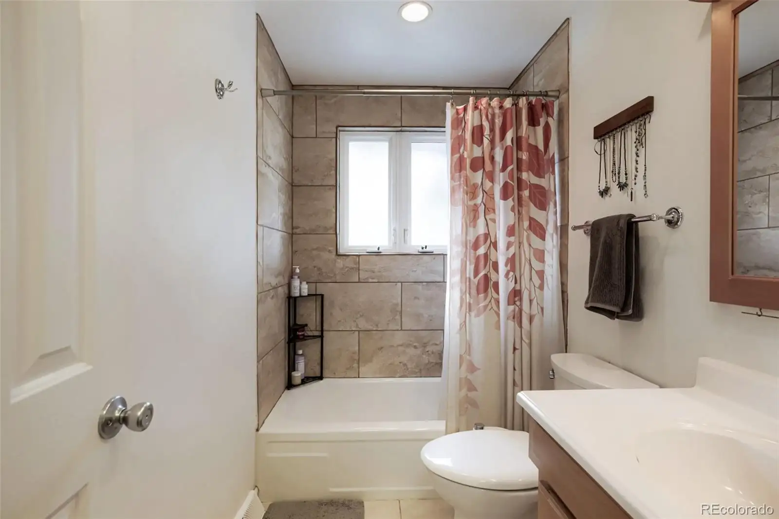 Main-level bathroom with a tiled tub and shower