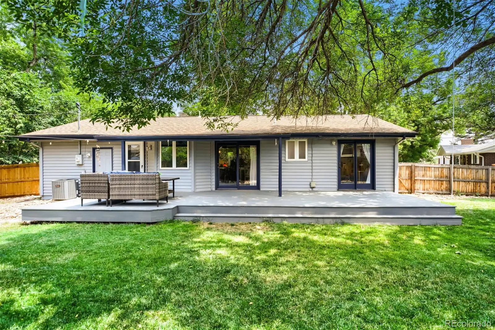 Rear exterior and deck seen from the backyard lawn