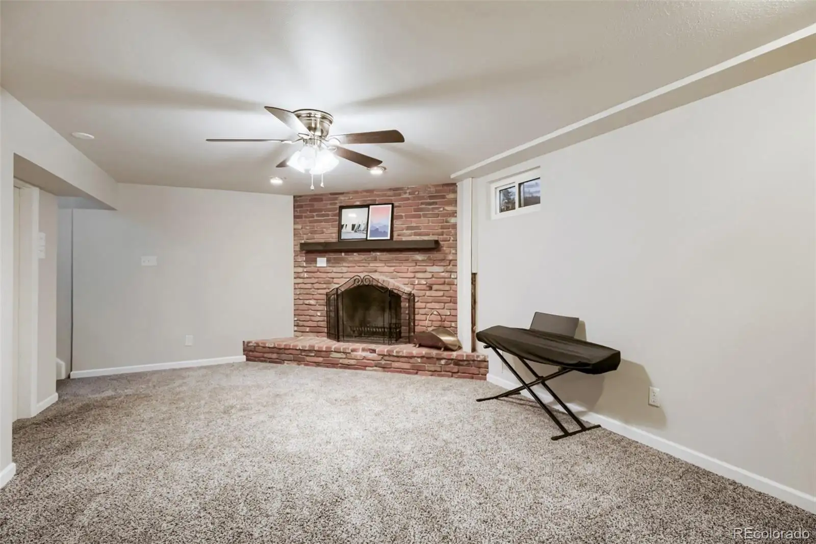 Finished basement family room with a brick fireplace